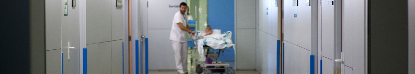 Imatge d'un passadís de l'Hospital de Sabadell on estan portant un pacient enllitat a la seva habitació  